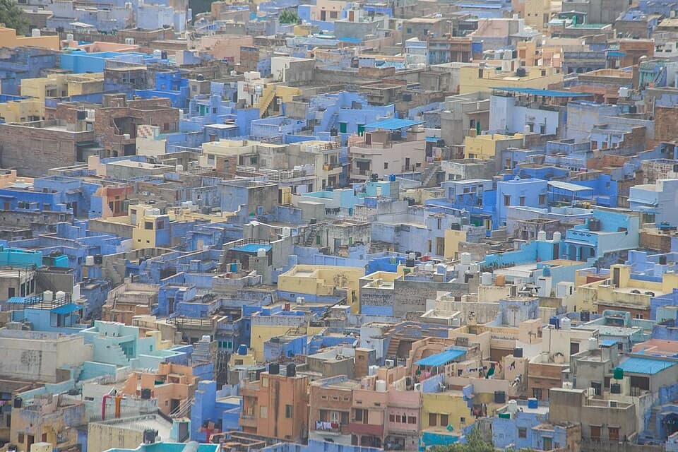 Tightly packed houses painted in shades of blue, with flat rooftops and water tanks, in the old city of Jodhpur